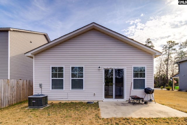 back of house featuring cooling unit, an outdoor fire pit, a patio area, and a lawn