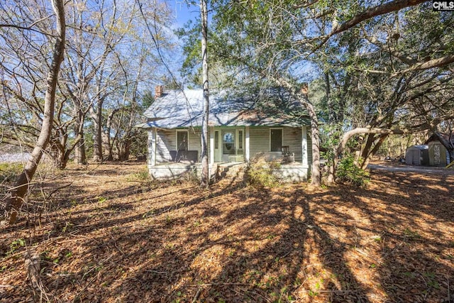 view of front of home featuring a porch and a storage unit