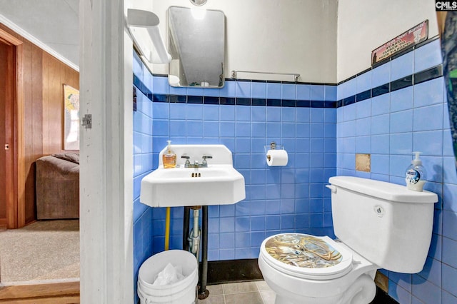 bathroom with tile patterned flooring, tile walls, and toilet