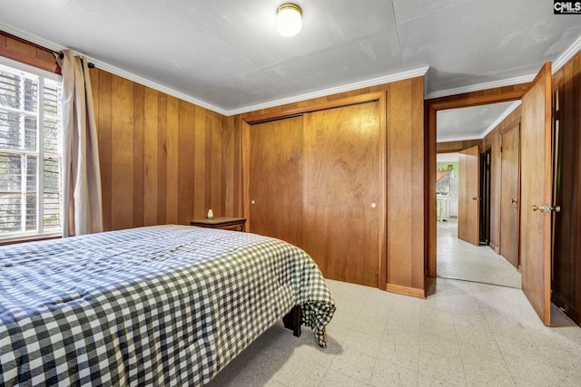 bedroom featuring crown molding, multiple windows, and wood walls