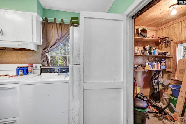 laundry room with washing machine and clothes dryer and wooden walls