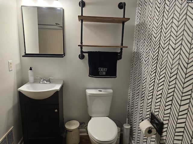 bathroom featuring vanity, toilet, and walk in shower