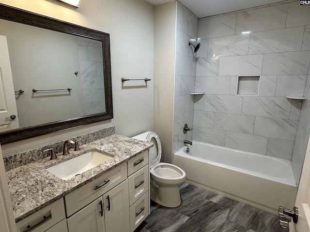 full bathroom with tiled shower / bath, vanity, toilet, and hardwood / wood-style floors