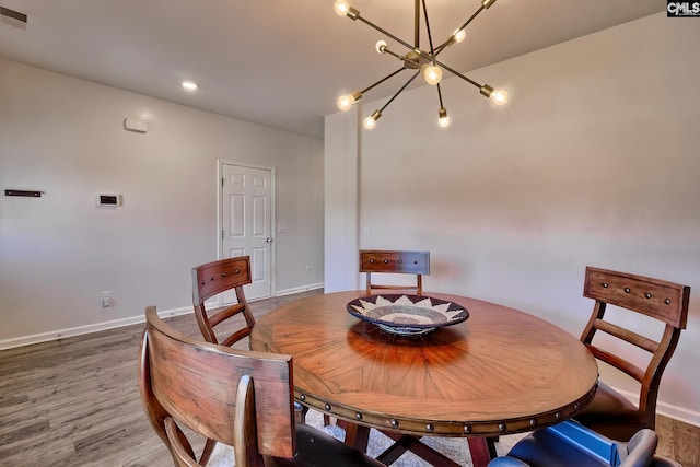 dining area featuring hardwood / wood-style flooring and a chandelier