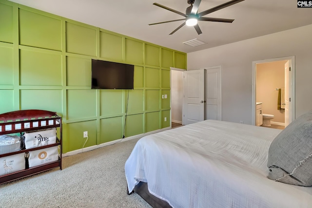 bedroom with connected bathroom, light carpet, and ceiling fan