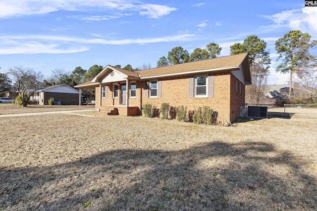 ranch-style home with cooling unit and a front yard