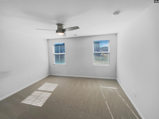 spare room featuring ceiling fan and carpet