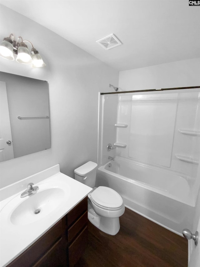 full bathroom with wood-type flooring, toilet, bathing tub / shower combination, and vanity