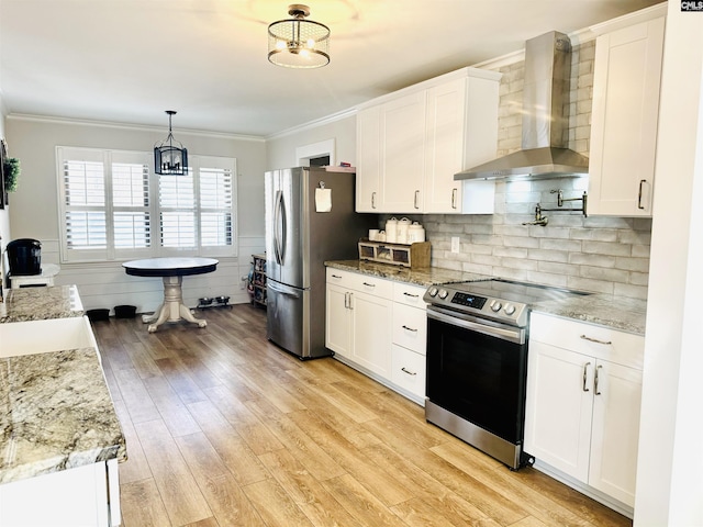 kitchen featuring appliances with stainless steel finishes, wall chimney exhaust hood, and white cabinets