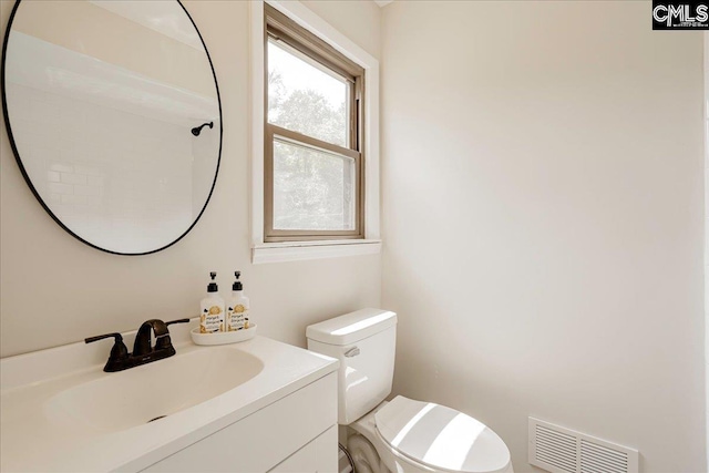 bathroom featuring visible vents, toilet, and vanity