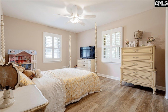 bedroom with baseboards, multiple windows, and light wood-style floors