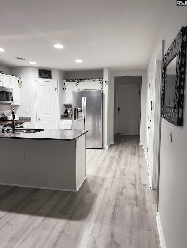 kitchen featuring white cabinetry, sink, stainless steel appliances, and light hardwood / wood-style floors