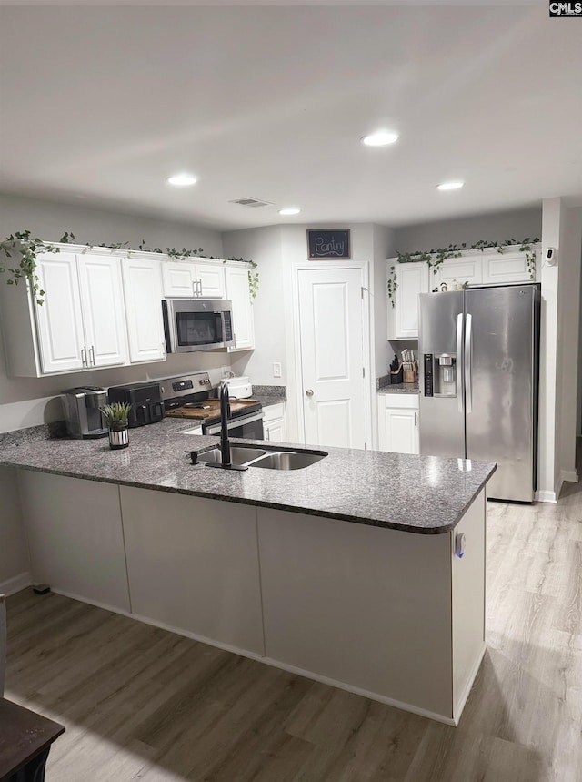 kitchen with white cabinetry, appliances with stainless steel finishes, and kitchen peninsula