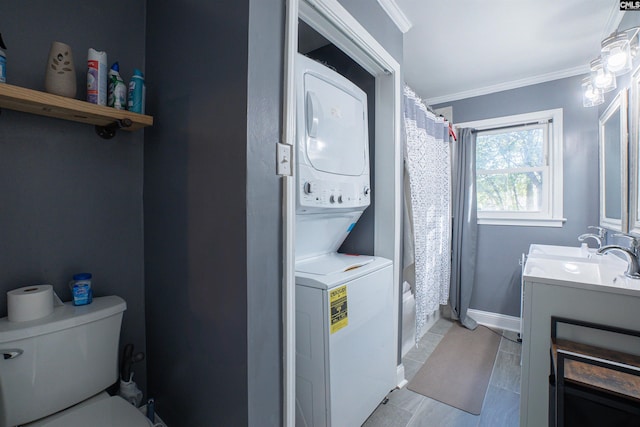 laundry room with crown molding, stacked washer and clothes dryer, and sink