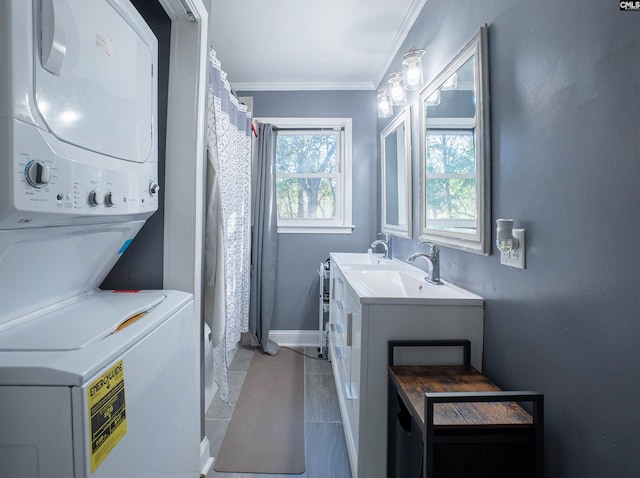 washroom featuring stacked washer and dryer, light tile patterned floors, ornamental molding, and sink