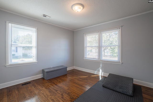 empty room featuring dark hardwood / wood-style flooring, ornamental molding, and a textured ceiling