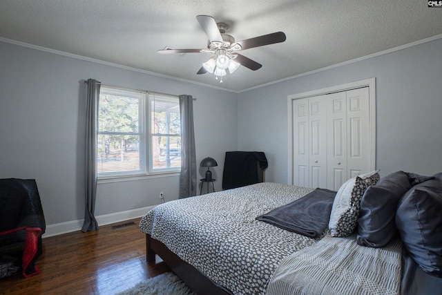 bedroom with dark hardwood / wood-style flooring, crown molding, and a closet