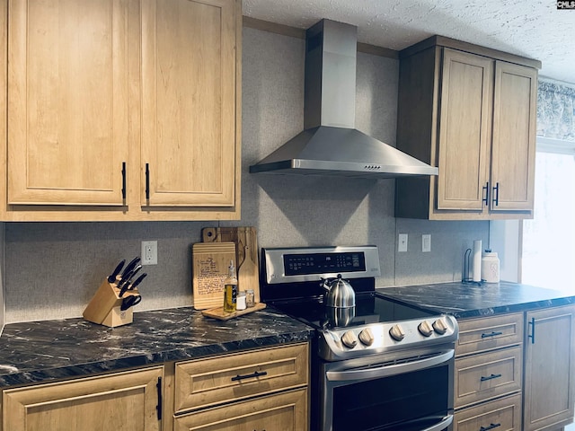 kitchen with light brown cabinets, wall chimney exhaust hood, stainless steel electric range, and a textured ceiling