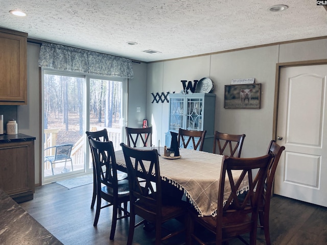 dining area featuring ornamental molding, dark hardwood / wood-style flooring, and a textured ceiling