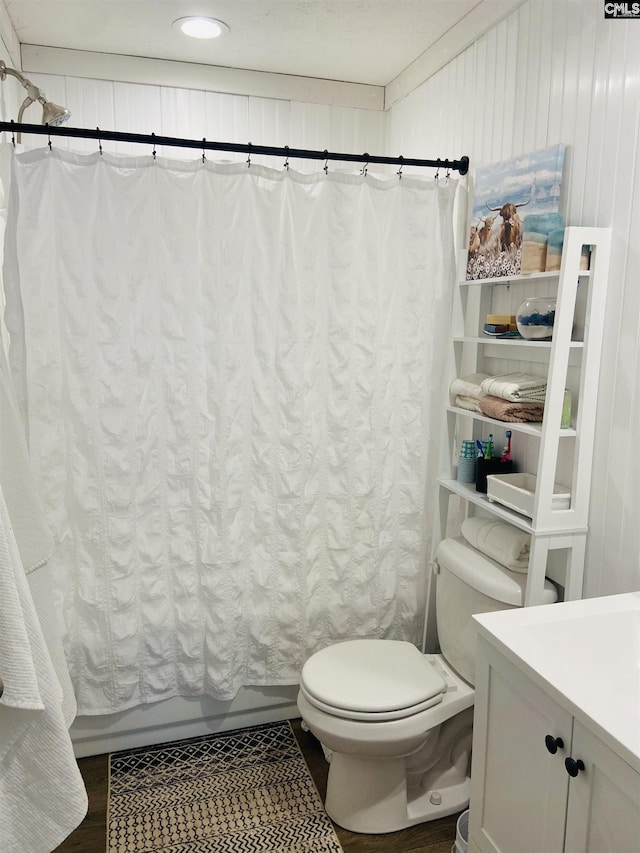 full bathroom featuring vanity, hardwood / wood-style floors, toilet, and shower / bath combo with shower curtain