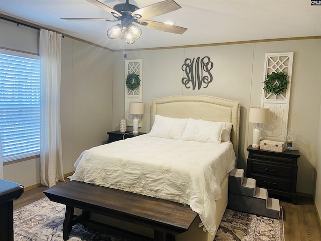 bedroom with ceiling fan, ornamental molding, and dark hardwood / wood-style flooring