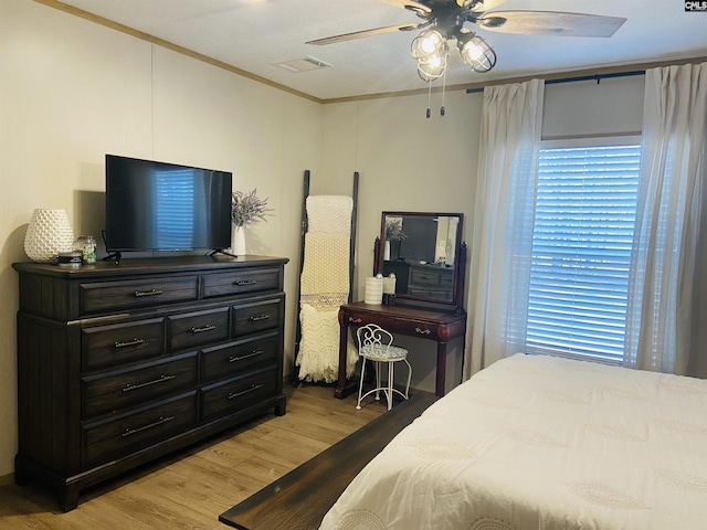 bedroom featuring crown molding, ceiling fan, light hardwood / wood-style floors, and multiple windows