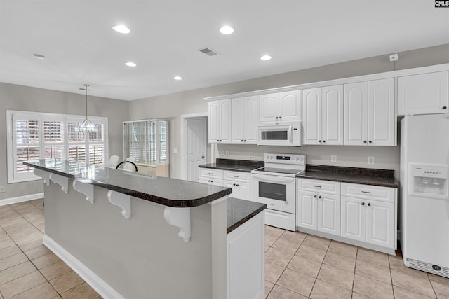 kitchen featuring white cabinetry, white appliances, light tile patterned flooring, and hanging light fixtures