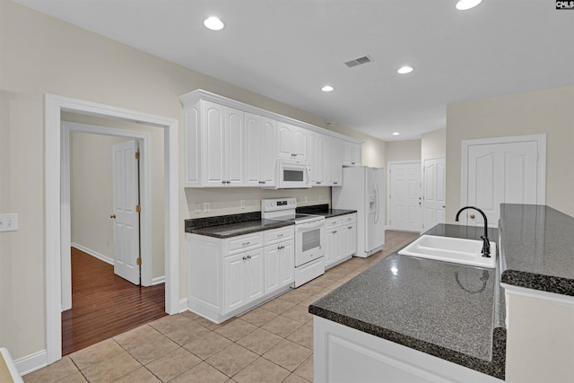 kitchen with white cabinetry, white appliances, sink, and light tile patterned floors