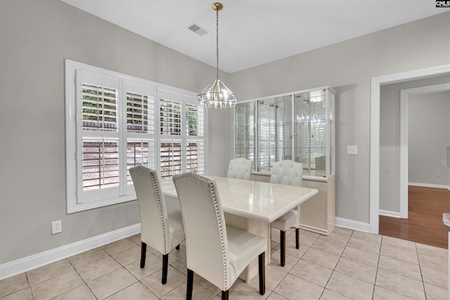 tiled dining room featuring an inviting chandelier