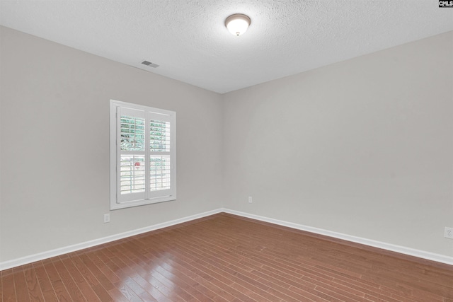 unfurnished room featuring hardwood / wood-style floors and a textured ceiling