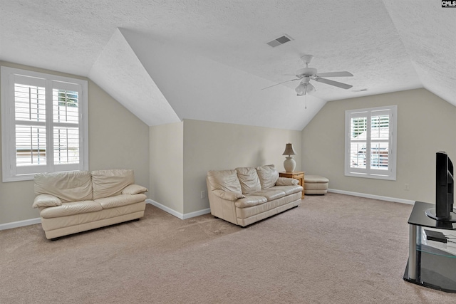 carpeted living room featuring ceiling fan, lofted ceiling, and a textured ceiling