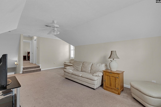 carpeted living room with ceiling fan, vaulted ceiling, and a textured ceiling