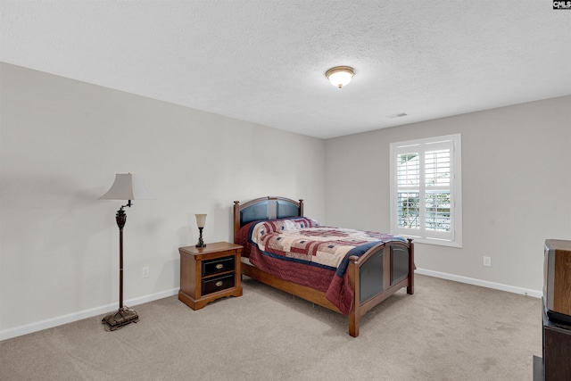 bedroom featuring light carpet and a textured ceiling