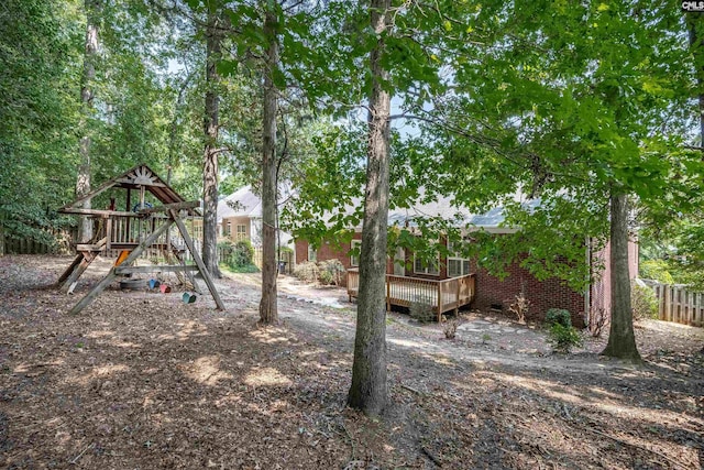 view of yard with a playground and a wooden deck