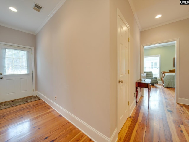 entryway featuring ornamental molding and light hardwood / wood-style flooring