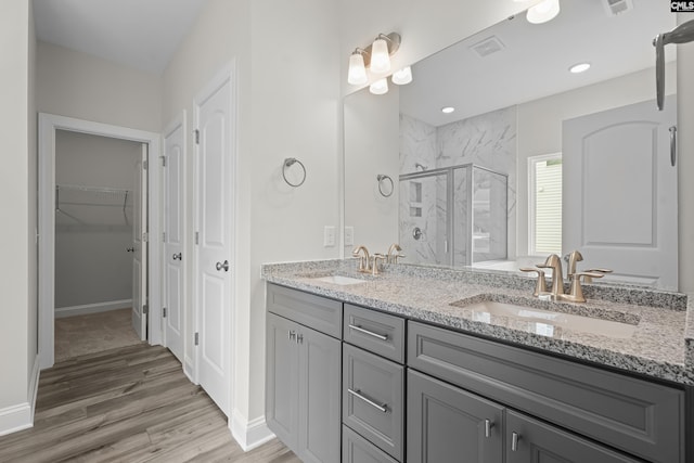 bathroom with vanity, hardwood / wood-style floors, and a shower with shower door