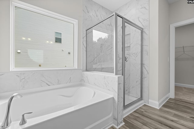 bathroom featuring wood-type flooring and shower with separate bathtub