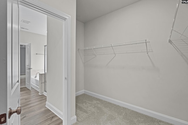 walk in closet with light wood-type flooring