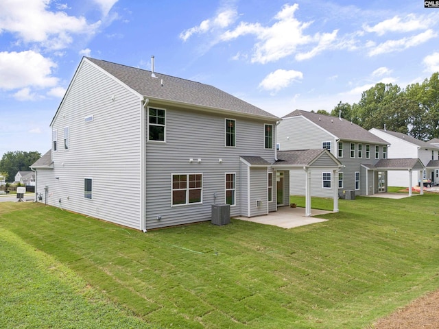 back of house with cooling unit, a patio, and a lawn