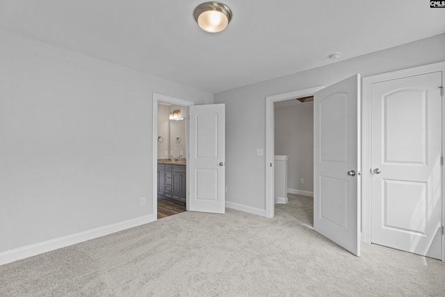 unfurnished bedroom featuring ensuite bath and carpet flooring