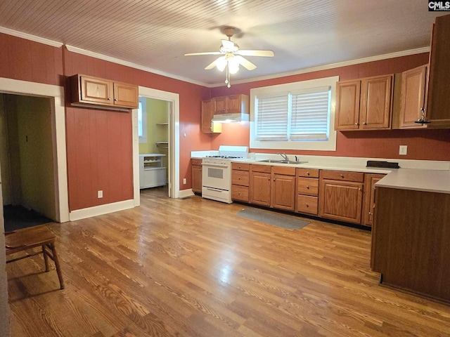 kitchen featuring white gas range, crown molding, sink, and light wood-type flooring