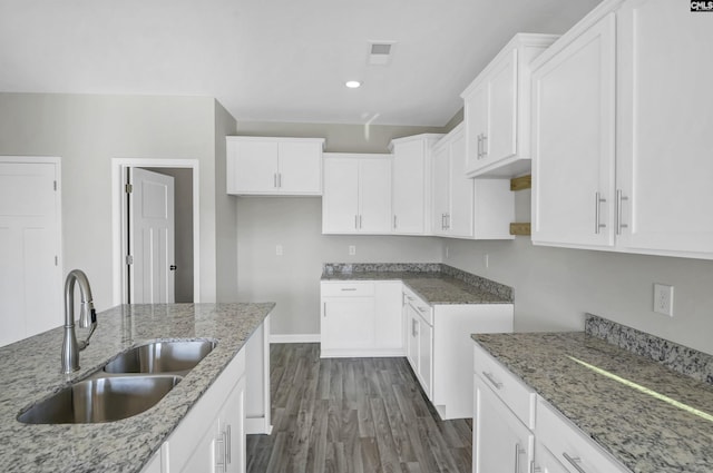 kitchen with white cabinetry, sink, dark hardwood / wood-style flooring, and light stone countertops