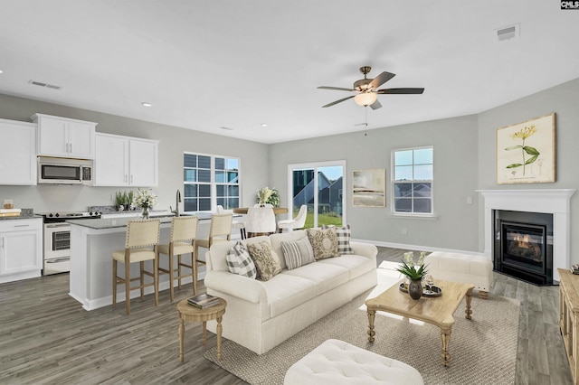 living room featuring ceiling fan and light hardwood / wood-style flooring