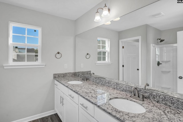 bathroom with vanity, a shower with shower door, and wood-type flooring