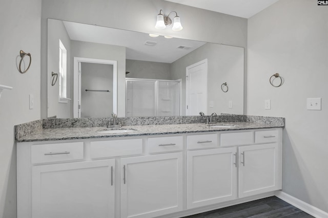 bathroom with a shower with door, vanity, and wood-type flooring