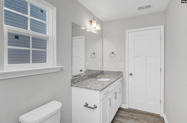 bathroom featuring vanity, hardwood / wood-style floors, and toilet