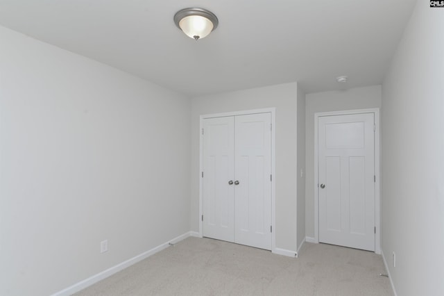 unfurnished bedroom with a closet and light carpet