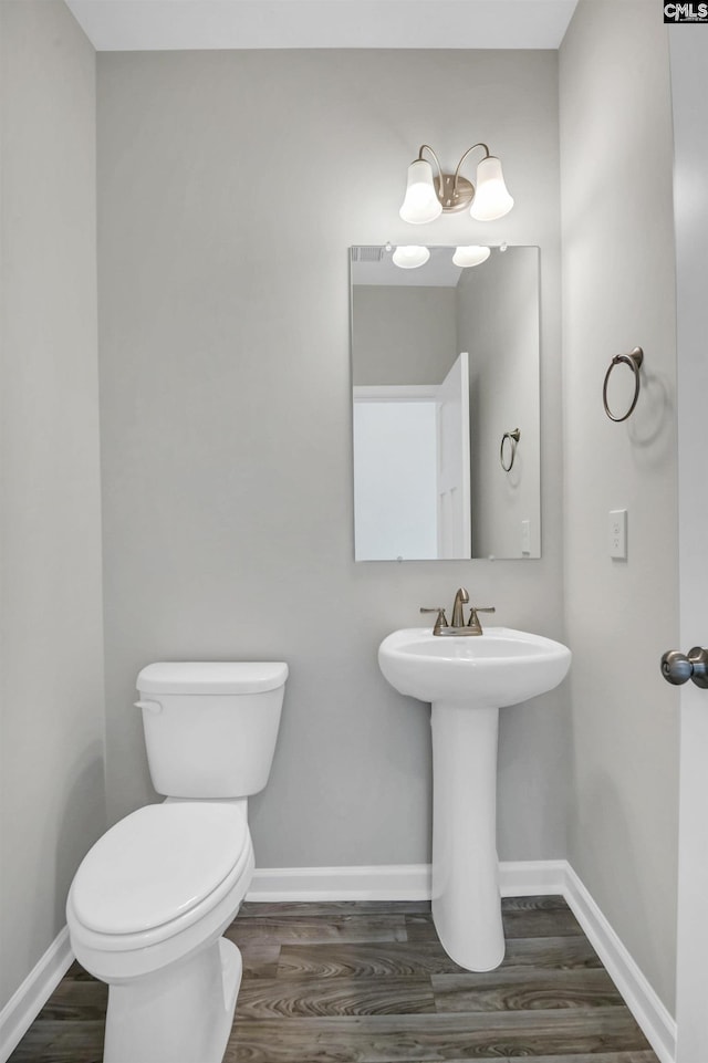 bathroom featuring hardwood / wood-style flooring and toilet