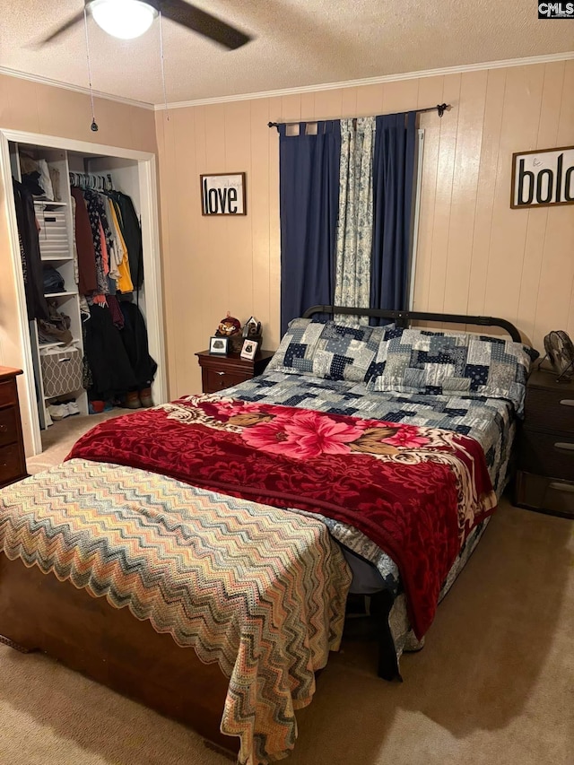 carpeted bedroom featuring crown molding, ceiling fan, and a textured ceiling