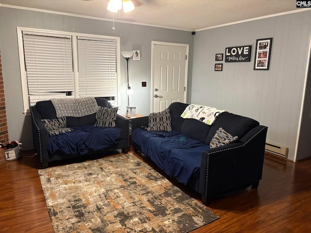 living room featuring a textured ceiling, baseboard heating, ornamental molding, dark hardwood / wood-style floors, and ceiling fan